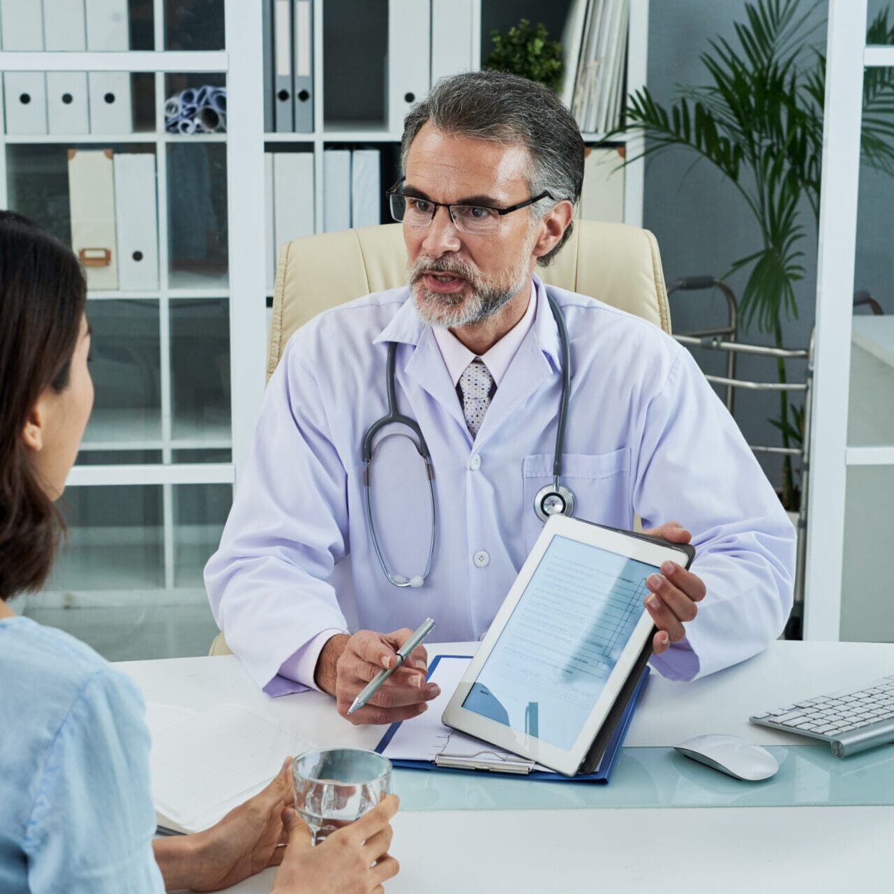 Doctor explaining diagnosis to female patient in his office